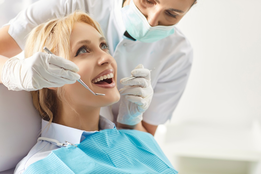 Smiling patient undergoing a cosmetic dental procedure to refine tooth shape and edges – tooth recontouring